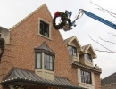 strathearn-in-toronto-at-work-hanging-wreath on genie lift by LawnSavers Professional Christmas Decorators